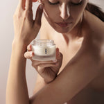 Donna che tiene il vasetto di Global Lux Cream accanto al viso